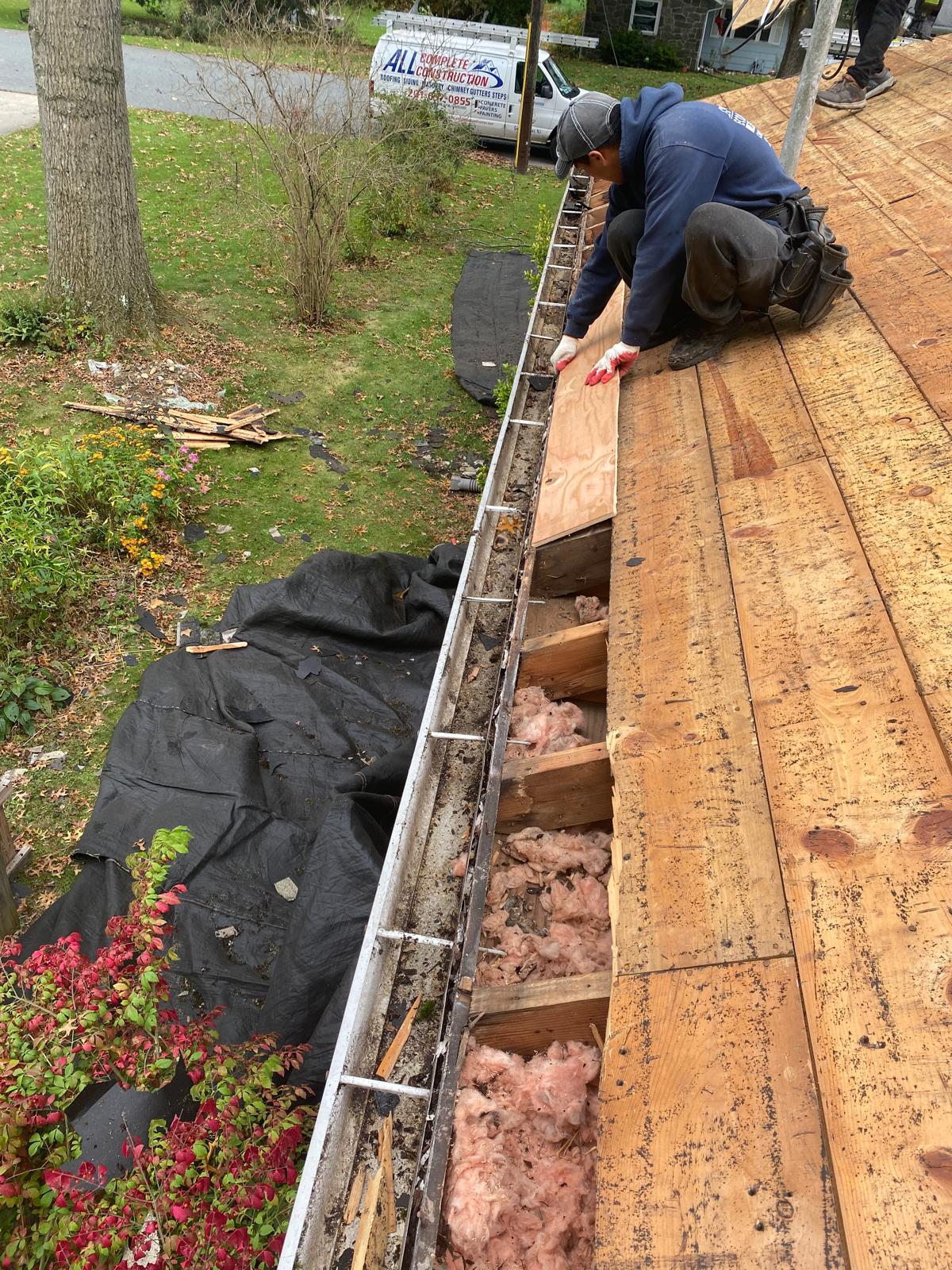 Roof decking repair with All American Roofing yard sign